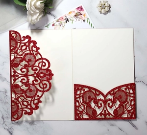 Close-up of laser-cut red glitter wedding invitation with elegant hollow pattern