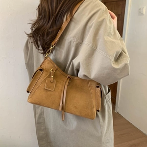 Detailed side view of vintage brown suede shoulder bag with FEIYER logo tag and fine stitching