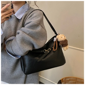 Détail du sac cabas noir vintage avec boucle en métal doré et pendentif ourson