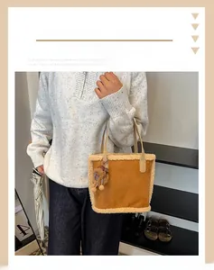 Détail du sac seau en daim caramel avec bordure en peluche crème et pompon décoratif