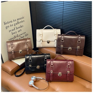 Retro messenger bags in five classic colors displayed on a premium leather sofa