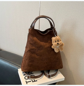 Détail d'un sac à dos en daim gaufré avec motifs mignons et pendentif ours en peluche