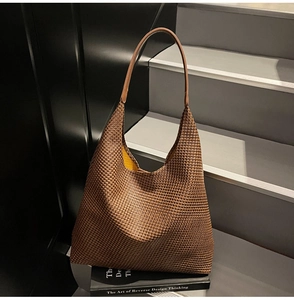 Detail of dark brown woven texture hobo bag featuring a contrast yellow lining
