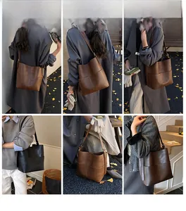 Dettaglio della grande borsa a secchiello in pelle opaca con spalline larghe e cuciture