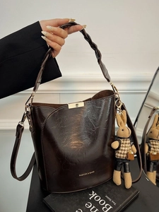 Dark brown oil wax leather bucket bag with woven handle and cute rabbit charm pendant