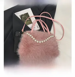 Dettaglio borsa di peluche rosa con trama in ecopelliccia e manico di perle bianche