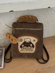 Brown corduroy puppy chef backpack with bread-shaped handle and plush charm detail