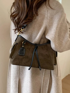 Vintage brown suede shoulder bag with contrast piping and stitching on wool coat