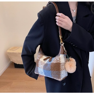 Detail der Vintage-Karo-Plüschtasche mit braunem Riemen und flauschigem Bommel