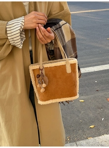 Détail du sac à main en daim marron avec garniture en fausse fourrure et pendentif peluche