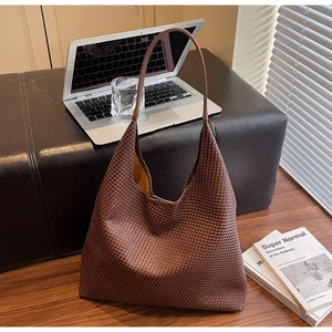 Macro shot of dark brown hand-woven leather texture on a spacious Hobo tote bag