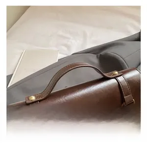 Detailed view of vintage dark brown leather handle with reinforced rivets and golden rings