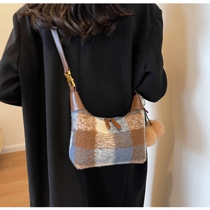 Detailansicht der Vintage-Plüschtasche mit Karomuster und Lederriemen am Modell