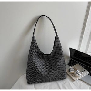 Detail of soft woven texture on a large black tote bag in a modern desk setting