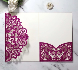 Detail of laser-cut fuchsia wedding invitation with glitter finish and pocket