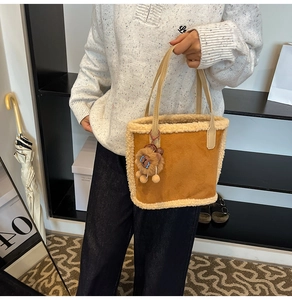 Vue détaillée du sac cabas en faux daim marron avec garniture en peluche et pendentif