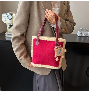 Détail du cabas en daim rouge avec bordure en fausse fourrure et pendentif d'ours
