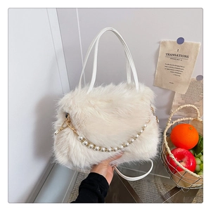 Dettaglio della borsa in peluche bianca con elegante catena di perle e fibbie dorate