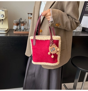 Détail du sac cabas en daim rouge avec bordure polaire et breloque lion en peluche
