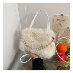 Dettaglio della borsa morbida bianco crema con catena di perle e texture in ecopelliccia