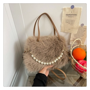 Dettaglio borsa a tracolla marrone di peluche con catena di perle e texture morbida