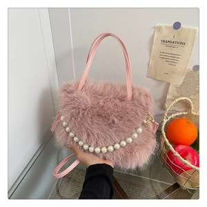 Dettaglio ravvicinato della borsa in ecopelliccia rosa con elegante catena di perle e tracolla