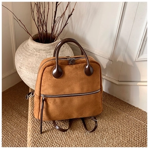 Détails du sac à dos en daim marron vintage avec bretelles en cuir sur tapis de jute