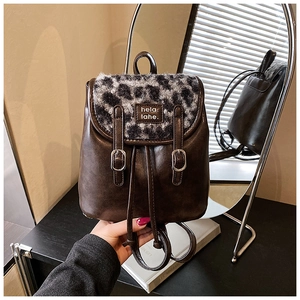 Dettaglio zaino retrò in pelle marrone scuro con patta leopardata e etichetta hela: lahe