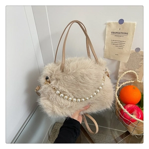 Dettaglio della borsa in peluche beige con catena di perle e morbida texture pelosa