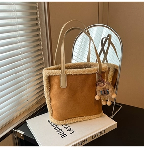 Détail du sac à main en daim marron avec bordure en laine d'agneau et pendentif ourson