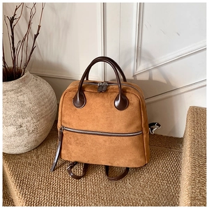 Détails du sac à dos en daim marron avec sangles en cuir foncé et fermetures éclair argentées