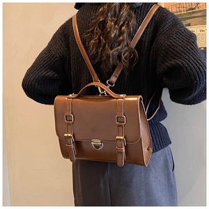 Detail of vintage brown messenger bag with metal buckles and detachable shoulder straps