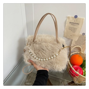 Dettaglio della borsa in pelliccia sintetica beige con catena di perle e manici