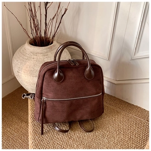 Détail d'un sac à dos vintage marron café en daim avec poignées en cuir élégantes