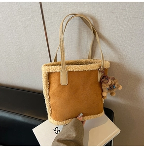 Vue détaillée du sac cabas en daim marron avec bordure en peau de mouton et breloque ours