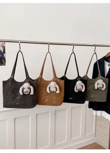 Row of large faux leather tote bags in four colors with cute white bunny pendants