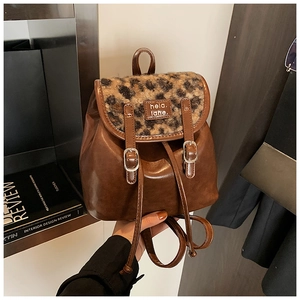 Dettaglio dello zaino vintage in pelle marrone con stampa leopardata e chiusura a fibbia
