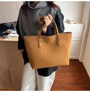 Detailed macro view of the vintage brown tote bag with metal rivets and fashion branding