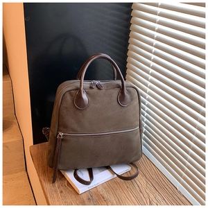 Vue détaillée du sac à dos en daim marron foncé avec fermetures éclair argentées