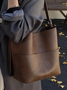 Secchiello vintage in pelle marrone con tasche a punto croce e tracolla regolabile