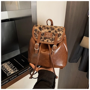 Dettaglio dello zaino in ecopelle marrone con patta leopardata e fibbie in metallo lucido