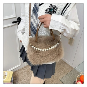 Dettaglio della borsa a spalla in peluche marrone con catena di perle e finta pelliccia