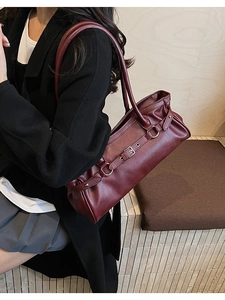 Vue macro du sac baguette vintage bordeaux en similicuir avec boucles et sangles argentées