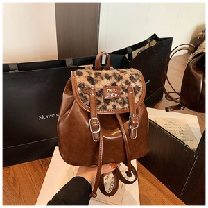 Dettaglio dello zaino vintage in pelle marrone con patta in ecopelliccia maculata leopard
