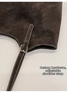 Detail of lychee pattern leather underarm bag with gold buckle and white contrast stitching