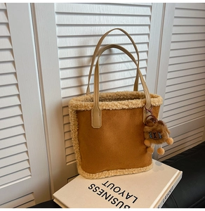 Détail d'un sac fourre-tout marron en faux daim avec bordure en polaire et breloque ours