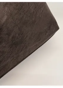 Macro shot of dark brown leather texture with elegant gold PAN'TOR LONDON brand logo