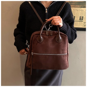 Détail d'un grand sac à dos en daim marron foncé avec poche à fermeture éclair argentée
