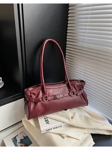 Gros plan sur le sac baguette vintage bordeaux en cuir mat avec une boucle en argent