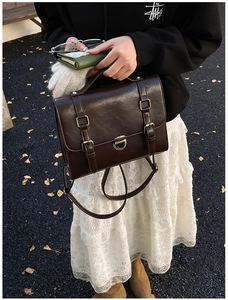 Detailed close-up of dark brown vintage satchel bag with retro bronze twist-lock hardware